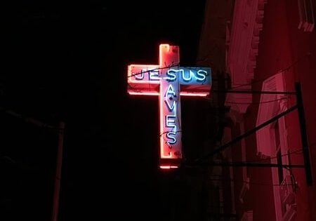 Image of neon cross that says jesus saves