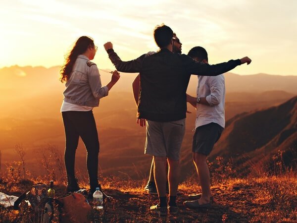 group of young adults outside during a sunset